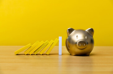 Piggy bank with falling domino pieces