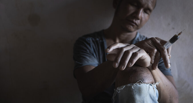 Syringe in overdose asian woman drug addict hand. drug overdose.Social disaster and epidemic of narcotic addiction concept.