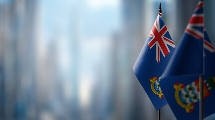 Small flags of the Cayman Islands on an abstract blurry background