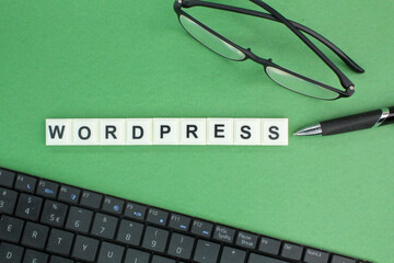 laptop keyboard, glasses and pen with Wordpress alphabet words. Wordpress concept