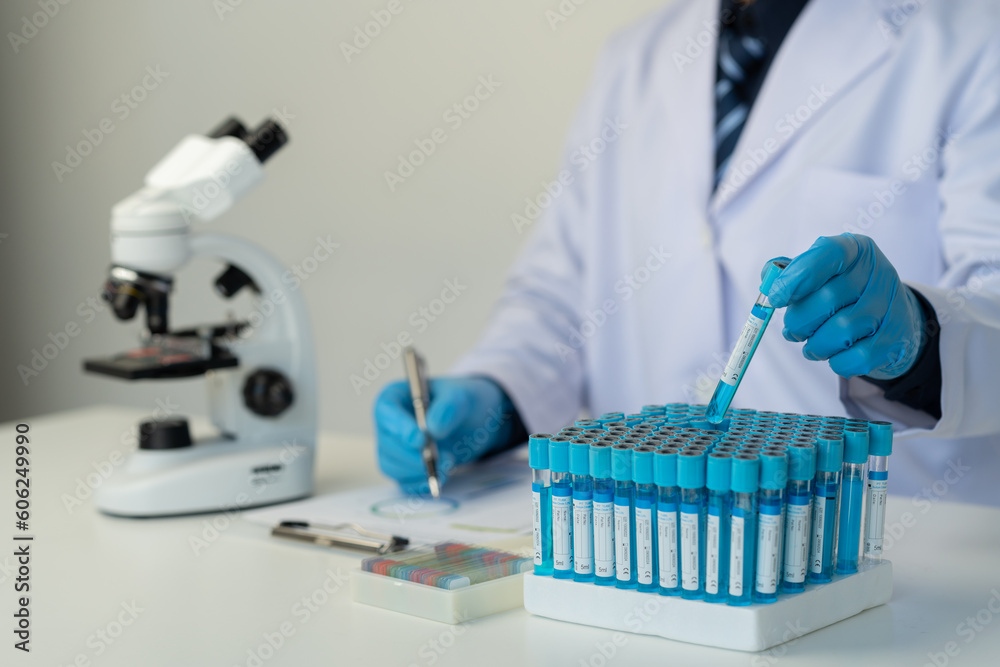 Wall mural cropped view of male scientist recording data using pill sampling tubes for analysis and testing, ad