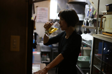 Fototapeta na wymiar 仕事終わりにビールを飲む女性