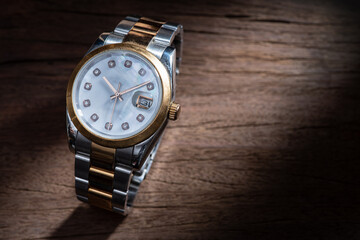 Old luxury wristwatch on old wooden background
