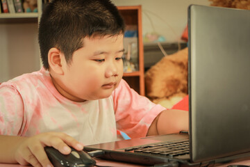 The boy sat and looked at the computer.