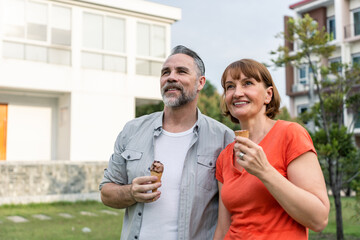 Caucasian senior man and woman having a picnic outdoors in the garden. 