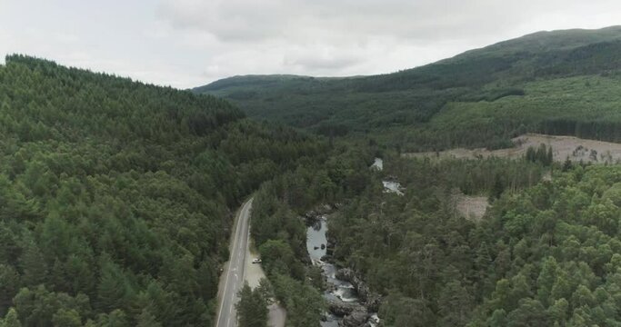 Wide to close drone shot of waterfalls and the surrounding forests along the North Coast 500 route to Fort Augustus and Loch Ness