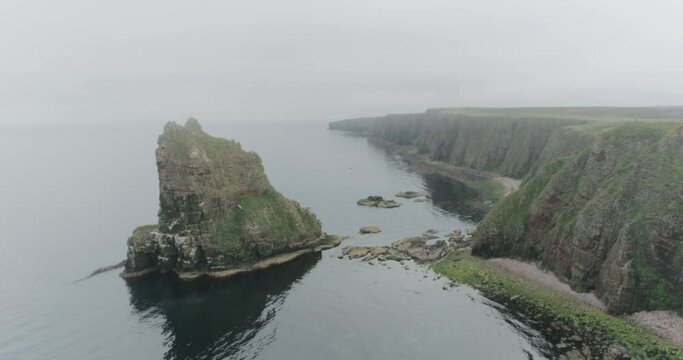 Slow static drone shot of the Stacks of Duncansby during misty weather along the Scotland North Coast 500 route at John O'Groats