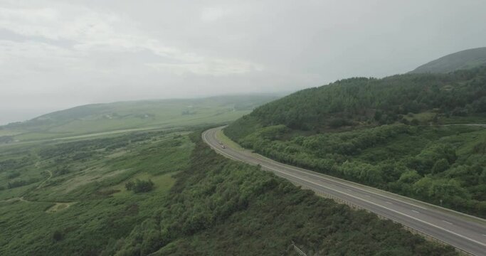 Wide drone shot of the A9 road with traffic moving in both directions on the Scotland North Coast 500 route