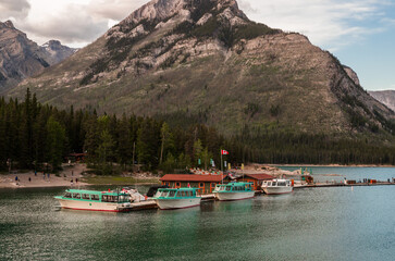 Summer vacation in the mountains. Active recreation - canoeing, kayaking - boat tour. A tourist magnet on the lake Minnewanka, Banff National Park, Alberta, Canada