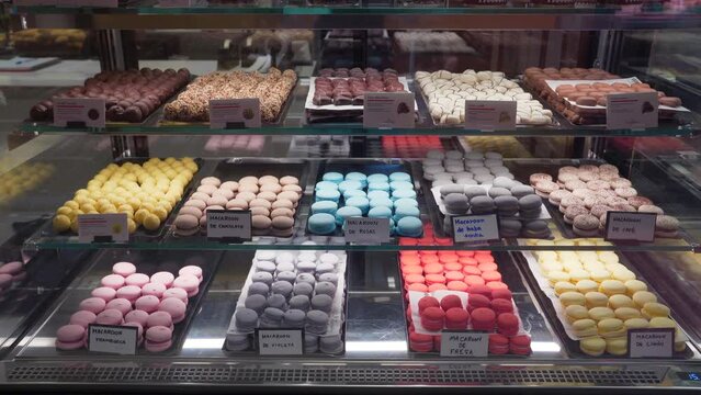 Refrigerated showcase of a cafeteria with truffles and macarons of different flavors and colors in the Central Market (Mercado Central) Valencia, Spain.