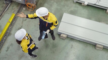 Top view of industrial engineers men and women wearing safety hard hat standing in plant while...