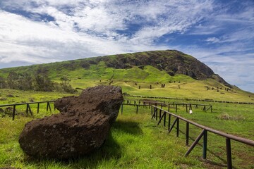 Fallen Moai Sculpture Lying in Grass Field below Rano Raraku, famous Archaeological Site, Rapa Nui Easter Island, Chile