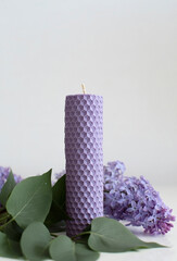 Handmade scented candles. A bush of May lilac and a lavender candle. Vertical photo.