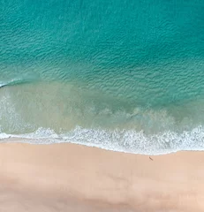 Aerial view of the ocean with surfers, wave and nice pristine blue water