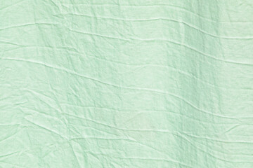abstract light green mint background of crumpled fabric
