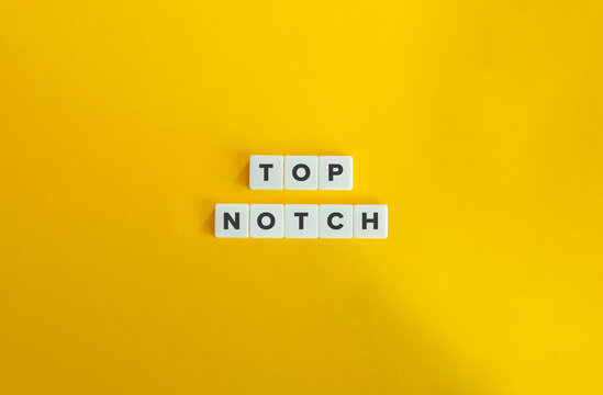 Top Notch Phrase on Block Letter Tiles on Yellow Background. Minimal Aesthetics.