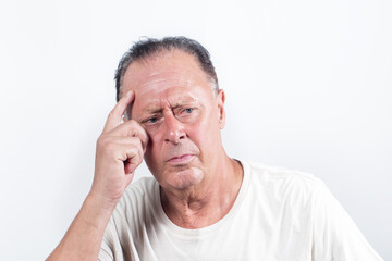 Serious middle-aged man with white shirt having doubts and with confuse face expression while scratching head on isolated white background