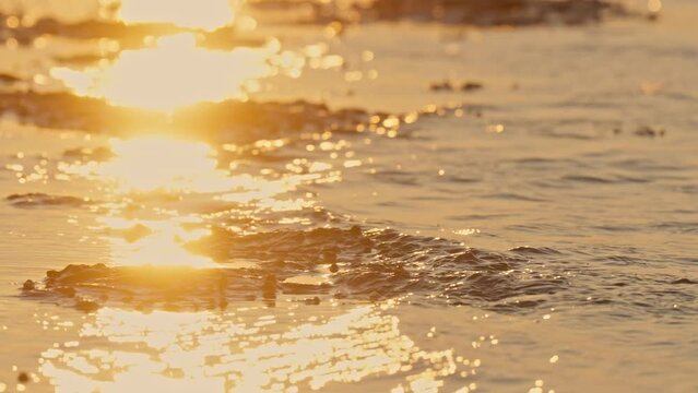 Small waves hitting the beach during a sunset in The Netherlands.