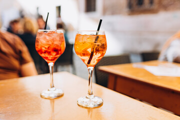Mezcal Negroni and Aperol Spritz Cocktails. Alcoholic beverage based on table with ice cubes...