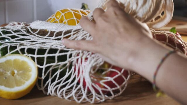 Zero waste and sustainable plastic free lifestyle. ecological life at home, woman pick up on natural fabric bag full of vegetable and fruits. organic food shopping. 
