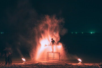 Fire steel wool with water reflection on sea in beach club party at night Samui Thailand