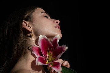 Obraz na płótnie Canvas Beauty girl with lily. Beautiful sensual woman flowers, studio close up portrait.