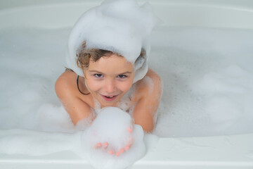 Kid bathes in a bath with foam.