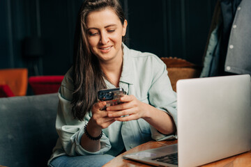 Happy smiling woman is using mobile phone for online chat.