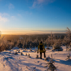 Fototapeta na wymiar Beautiful amazing sunset winter mountains. A man goes a sport hike in snow holidays. Christmas background. Unique landscape. Mt lysa, beskydy mountains in czech