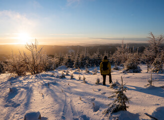 Beautiful amazing sunset winter mountains. A man goes a sport hike in snow holidays. Christmas...
