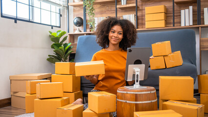 Naklejka premium African American business woman working at warehouse preparing SME package box for delivery at small business home office.