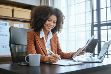 Working smart, African american business woman working audit balance sheet, job order costing,...