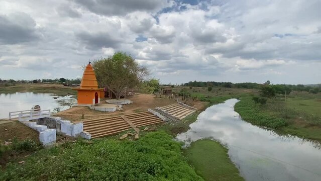 Unique landscape of Jharkhand with a beautiful yellow temple and a river and farm in the background.