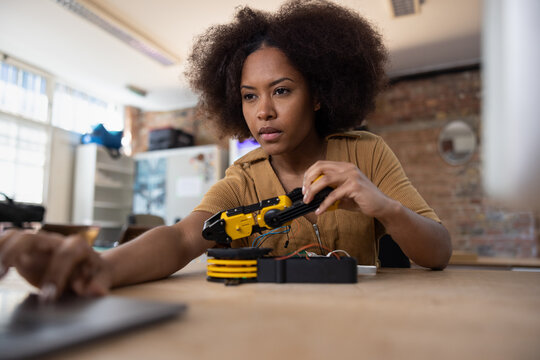 African american woman working on robotic technology using a laptop