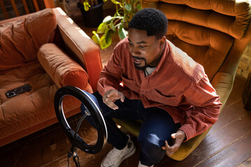 Male influencer recording a vlog in a cool loft studio apartment