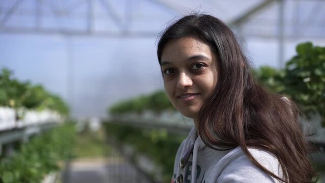 Young South Asian Woman In A Cultivation House Fruit Farm. Close Up
