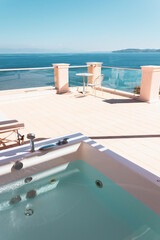 Fototapeta premium Terrace with sun loungers, outdoor hot tub and sea views. Relaxed holidays in a Mediterranean resort in Greece