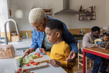 Mom helping son make a sandwich