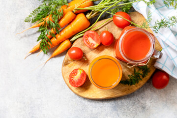 Tomato and carrot juice in a glasses on a stone table. Vitamins drinks juice carrot and tomato. Healthy lifestyle. View from above. Copy space.