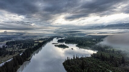 Fototapeta na wymiar Aerial shot of a river under a cloudy sky in Invermere, BC, Canada.