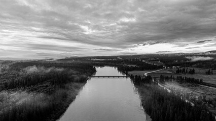 Grayscale aerial shot of a river under a cloudy sky in Invermere, BC, Canada.
