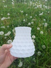 3D printed vase. Multicolored 3D printed vase among green grass