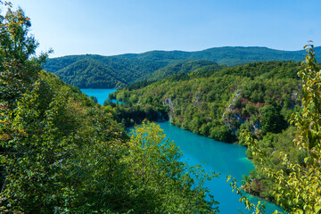 Obraz na płótnie Canvas Plitvice, Croatia - Panoramic view of the beautiful waterfalls of Plitvice Lakes in Plitvice National Park on a bright summer day with blue sky and clouds and green foliage and turquoise water