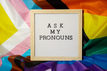 ASK MY PRONOUNS text Neo pronouns concept on Rainbow flag background gender pronouns. Non-binary...