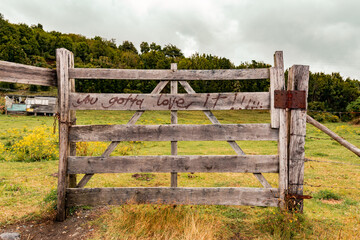 Closeup of a wooden fence with "you gotta love it!!!" inscription in Valdivia, Chile