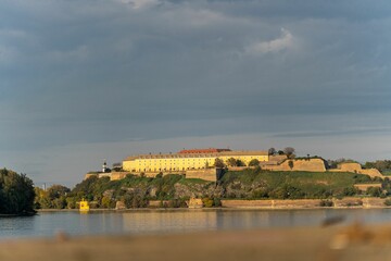 Fototapeta premium Sat Na Petrovaradinskoj Tvrdjavi with a lake view on a sunny day, cloudy sky in the background