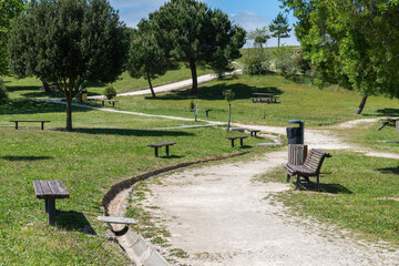 Scenic view of path amid the green park with wooden benches surrounded by trees in Loures, Portugal