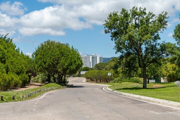 Empty street with modern buildings in the background with green trees in Troia, Portugal
