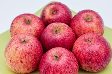 Top view of red apples of pero bravo esmolfe species washed with fresh water on a green plate