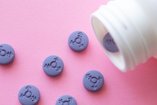 Transgender pills. Hormonal pills. A purple pill with a transgender gender symbol in a bottle. Tallets for LGBT people